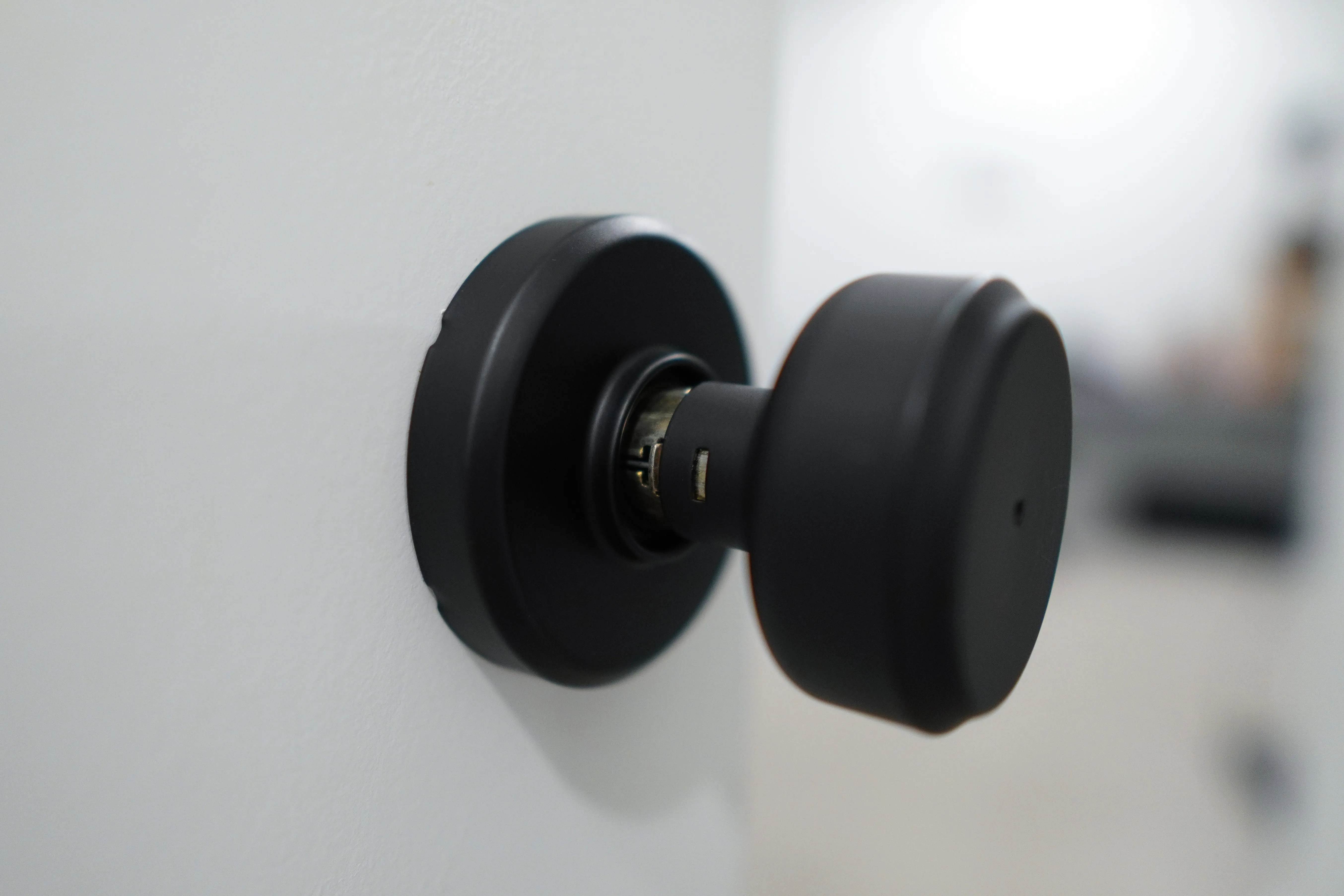 A bare Bowery knob on the door, showing the exposed spindle and the rectangular release slot in the knob's neck