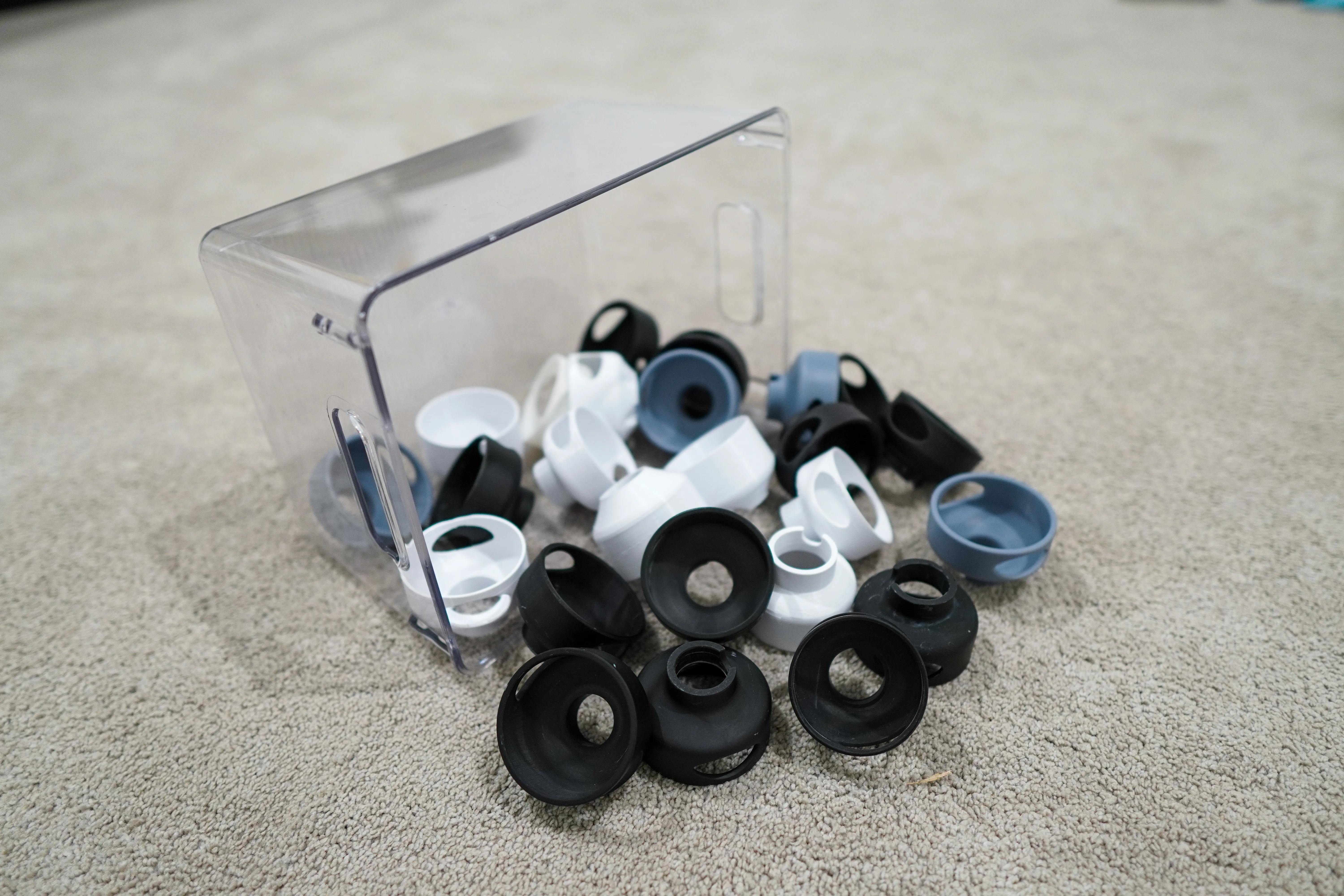 A bin of printed prototype covers in black, white and grey resin